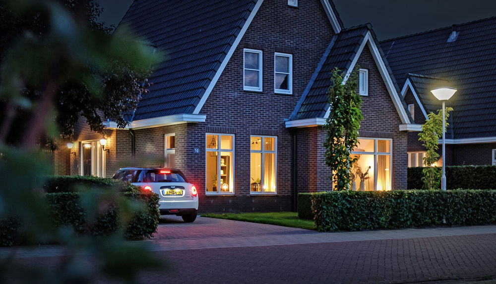 Heldere LED buitenlampen in een moderne woonwijk bij schemering, zorgt voor sfeervol en functioneel buitenverlichting voor huis en tuin.